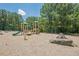 A playground with slides, rock features, and swings surrounded by mature trees at 2304 Mitford Ct, Dacula, GA 30019
