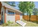 Backyard shed featuring neutral siding, a wood door, and a ramp, offering ample storage space at 2304 Mitford Ct, Dacula, GA 30019