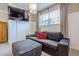 Cozy sitting room with grey love seat, ottoman, TV, modern lighting and large window at 2304 Mitford Ct, Dacula, GA 30019