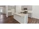 The kitchen features gray cabinets, a large island with a sink, stainless steel appliances, and hard wood floors at 80 Hampton Ter, Dallas, GA 30157