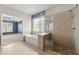 Bathroom featuring a glass shower, soaking tub beneath a decorative window and view into the bedroom at 4677 Prater Se Way, Smyrna, GA 30080