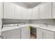 Well-lit laundry room with modern washer, dryer, ample cabinetry, a sink, and counterspace at 4677 Prater Se Way, Smyrna, GA 30080