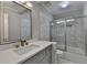 Modern bathroom features a glass enclosed shower, tile walls, and a gray vanity at 4901 Briarleigh Chase Sw, Mableton, GA 30126