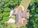 Expansive aerial view of the home showcasing the roof, outdoor deck, driveway, and landscaping surrounded by lush greenery at 8443 Marina Bay Ct, Jonesboro, GA 30236