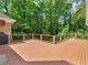 Large, freshly-stained wooden deck overlooking a lush, wooded backyard at 8443 Marina Bay Ct, Jonesboro, GA 30236