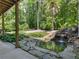 This covered patio is equipped with stone flooring and has a stunning view of the water feature at 8443 Marina Bay Ct, Jonesboro, GA 30236