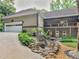 Exterior view of rear exterior with a rock and waterfall detail in the backyard and multiple garages at 8443 Marina Bay Ct, Jonesboro, GA 30236