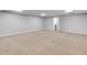 Open basement with plush neutral carpet, light gray walls, and a bright, clean aesthetic at 8443 Marina Bay Ct, Jonesboro, GA 30236