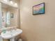 Traditional half bathroom featuring a pedestal sink, artwork, and natural light from the window at 8443 Marina Bay Ct, Jonesboro, GA 30236