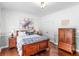 Inviting bedroom boasts wood floors, decorative wall trim, a rich wood bed frame, and an accent chair at 8443 Marina Bay Ct, Jonesboro, GA 30236