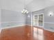 Bright dining room featuring hardwood floors, a modern chandelier, and large window at 8443 Marina Bay Ct, Jonesboro, GA 30236