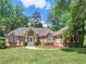 Beautiful single Gathering home with a lush green lawn, garden beds with red mulch, and an elegant walkway to the front door at 8443 Marina Bay Ct, Jonesboro, GA 30236