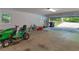 Spacious garage with open door showing lawn equipment, tools, and two windows providing natural light at 8443 Marina Bay Ct, Jonesboro, GA 30236