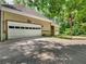 Three car garage with a palm tree in the front yard and lush greenery at 8443 Marina Bay Ct, Jonesboro, GA 30236