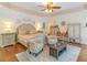 Comfortable primary bedroom with sitting area, decorative ceiling, and hardwood floors at 8443 Marina Bay Ct, Jonesboro, GA 30236
