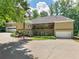 Home's rear exterior with a lush green lawn, rear patio, and multiple garages at 8443 Marina Bay Ct, Jonesboro, GA 30236