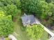 Aerial view of a brick home with a well-maintained yard, mature trees, and a basketball court, showcasing its serene setting at 870 River Cliff Ct, Suwanee, GA 30024
