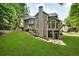 A multi-story home with a well-manicured lawn, stone walkway, and ample windows offering natural light and outdoor views at 870 River Cliff Ct, Suwanee, GA 30024