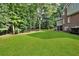 Expansive grassy backyard with screened porch, ideal for outdoor activities and relaxation, bordering a lush wooded area at 870 River Cliff Ct, Suwanee, GA 30024