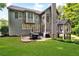 Backyard view of large home showing a patio, dining area, and lush landscaping at 870 River Cliff Ct, Suwanee, GA 30024