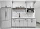 Stylish wet bar features gray cabinetry, stainless steel appliances, and a modern sink with tiled backsplash at 870 River Cliff Ct, Suwanee, GA 30024
