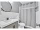 Modern bathroom features a sleek vanity, round mirror, shower with subway tile, and stylish gray accents at 870 River Cliff Ct, Suwanee, GA 30024