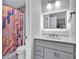 Updated bathroom featuring a modern vanity with illuminated mirror, colorful shower curtain, and sleek fixtures at 870 River Cliff Ct, Suwanee, GA 30024
