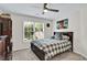 Well-lit bedroom with ceiling fan, window views, dark furniture, and a comfortable bed at 870 River Cliff Ct, Suwanee, GA 30024