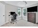 Office space with a black leather chair, sleek desk, a wall mounted TV and windows with natural light at 870 River Cliff Ct, Suwanee, GA 30024