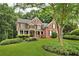 Traditional two-story brick home with well-maintained landscaping and mature shade tree in the front yard at 870 River Cliff Ct, Suwanee, GA 30024