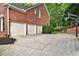 A brick home's three-car garage with a basketball hoop, offering ample parking and recreational space at 870 River Cliff Ct, Suwanee, GA 30024