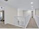 Bright hallway with white railings overlooking the stairs and neutral colored walls and carpet at 870 River Cliff Ct, Suwanee, GA 30024