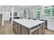 Open-concept kitchen features a large island with white countertop and stainless steel microwave at 870 River Cliff Ct, Suwanee, GA 30024