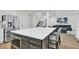 Spacious kitchen with stainless steel refrigerator, seating at island, and open view to the living room at 870 River Cliff Ct, Suwanee, GA 30024