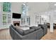 Open concept living room with a brick fireplace, large windows, and seamless access to the kitchen at 870 River Cliff Ct, Suwanee, GA 30024