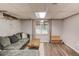 Finished basement offers a gray couch, wood floors, and natural light from a window at 905 Foxfire Dr, Lawrenceville, GA 30044