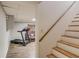 Finished basement with a staircase, wood floors, a treadmill and comfortable seating at 905 Foxfire Dr, Lawrenceville, GA 30044