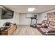 Finished basement with a wall-mounted tv, wood floors, a treadmill and comfortable seating at 905 Foxfire Dr, Lawrenceville, GA 30044