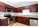 Kitchen features stainless steel appliances, wood cabinetry, and tile backsplash at 1122 Cotton Gin Dr, Woodstock, GA 30188