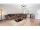 Cozy living room with brown sectional sofa, wood floors, ceiling fan, and decorative lighting at 1122 Cotton Gin Dr, Woodstock, GA 30188