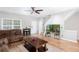 Spacious living room with wood floors, sectional sofa, ceiling fan, and mounted television at 1122 Cotton Gin Dr, Woodstock, GA 30188