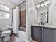 Bathroom features a combined shower-tub, tile flooring, and gray vanity with a white countertop at 237 Libby Ln, Canton, GA 30115