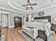 Spacious bedroom featuring hardwood floors, a tray ceiling, and a decorative ceiling fan at 237 Libby Ln, Canton, GA 30115