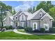 Elegant two-story home with a stone chimney, arched windows, and a beautifully landscaped front yard at 237 Libby Ln, Canton, GA 30115