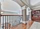 Upstairs hallway with hardwood floors, a dark iron railing, white trim, and a built-in bookcase at 237 Libby Ln, Canton, GA 30115