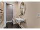 Elegant powder room featuring a pedestal sink, oval mirror, and textured wallpaper at 3773 Randall Se Rd, Atlanta, GA 30339