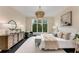 Bright main bedroom with large windows, chandelier, dark floors, and neutral furniture at 3773 Randall Se Rd, Atlanta, GA 30339