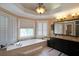 Bright bathroom boasts a large soaking tub, granite countertops, and decorative lighting at 5617 Asheforde Ln, Marietta, GA 30068