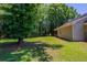 Lush backyard featuring mature trees and a well-maintained lawn, ideal for outdoor activities at 1406 Windy Ridge Se Ct, Conyers, GA 30013
