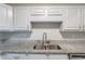 This bright kitchen offers updated countertops, stainless sink and updated white cabinets at 1406 Windy Ridge Se Ct, Conyers, GA 30013